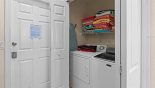 Villa rentals near Disney direct with owner, check out the Laundry facility in cupboard in kitchen with washer, dryer, iron and ironing board