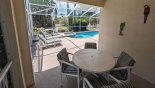 Cobered lanai with patio table & 4 chairs - additional table on pool deck wih 2 more chairs with this Orlando Villa for rent direct from owner