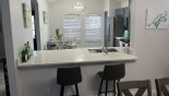 Dining area viewed towards kitchen with breakfast bar & 2 bar stools - www.iwantavilla.com is the best in Orlando vacation Villa rentals