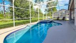 West facing pool & spa with views of trees and golf course beyond - photo taken in the earl morning hence shadow with this Orlando Villa for rent direct from owner