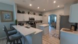 Kitchen with breakfast bar and 3 bar stools - arched opening leads to dining room - www.iwantavilla.com is your first choice of Villa rentals in Orlando direct with owner